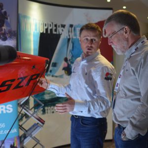 Duncan at RYA Dinghy Show discussing the WASZP on display to a customer